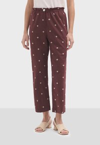 pantalons en velours côtelé bordeaux avec un motif en diamants, taille élastique et jambes droites, dotés d'un bouton avant et de poches.