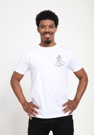 Homme souriant aux cheveux bouclés portant un t-shirt blanc avec un petit dessin noir d'une femme en robe sur la poitrine.