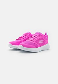 Zapatillas deportivas rosas con parte superior de tela de malla, suela blanca plana y cordones a juego. Presentan un detalle de logo y una pestaña en el talón trasero para facilitar su colocación.