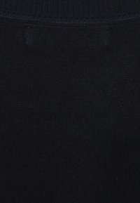 Schwarzer Strickstoff mit einem strukturierten Muster. Verfügt über einen gerippten Taillenbund oben und eine glatte Oberfläche über die gesamte Fläche.