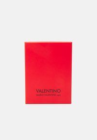 Červená obdélníková krabice s lesklým povrchem, na přední straně se středovým černým textem "VALENTINO MARIO VALENTINO spa".