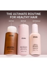 Three OUAI hair care bottles labeled Detox Shampoo, Bond Repair Balm, and Leave In Conditioner, representing a healthy hair routine.