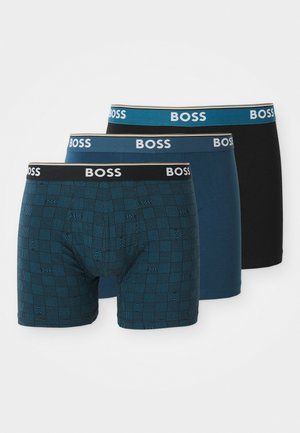Trzy pary bokserek w różnych kolorach: wzorzyste ciemnoniebieskie, gładkie niebieskie i gładkie czarne. Wszystkie mają elastyczny pas z logotypem "BOSS".