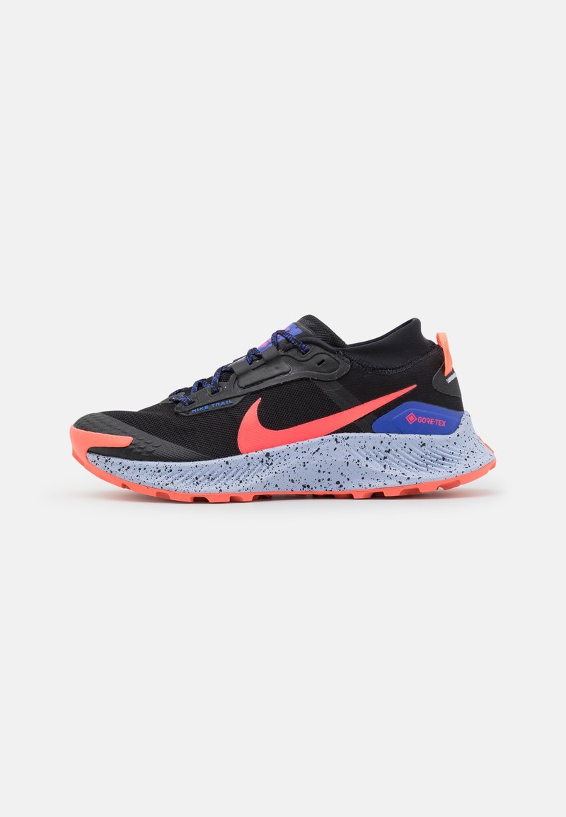 Chaussure de trail Nike noire et corail avec semelle grise mouchetée, accents violets et bleus, et marquage Gore-Tex sur le talon.