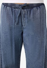 Τζιν παντελόνι με ελαστική μέση σε ανοιχτό μπλε χρώμα και κορδόνι. Διαθέτει χαλαρή γραμμή και μαλακή υφή, κατάλληλο για καθημερινή χρήση.