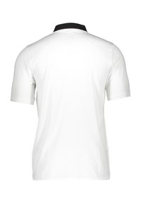 Polo shirt blanc à manches courtes avec un col noir et une texture lisse, conçu pour un ajustement cintré au dos.