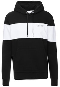 Felpa con cappuccio a righe bianche e nere in cotone, dotata di tasca anteriore, coulisse e piccolo logo del marchio sul petto.