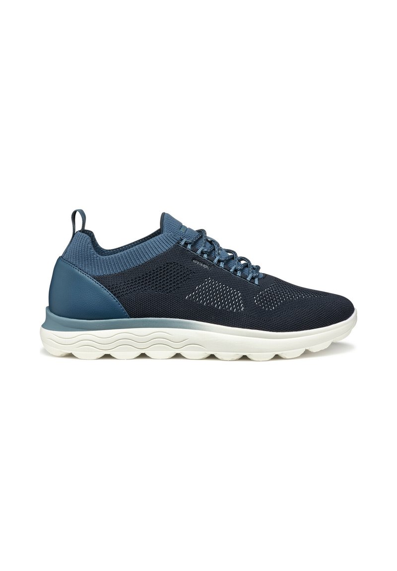 Sneakers in rete blu navy con una tomaia testurizzata, dettagli blu chiaro e una suola bianca spessa con un motivo a onde per comfort e supporto.