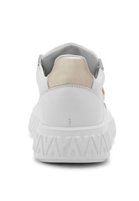 Sneaker bianco con tomaia in pelle liscia e un accento oro chiaro sul tallone. Suola spessa e testurizzata con un motivo a zigzag.