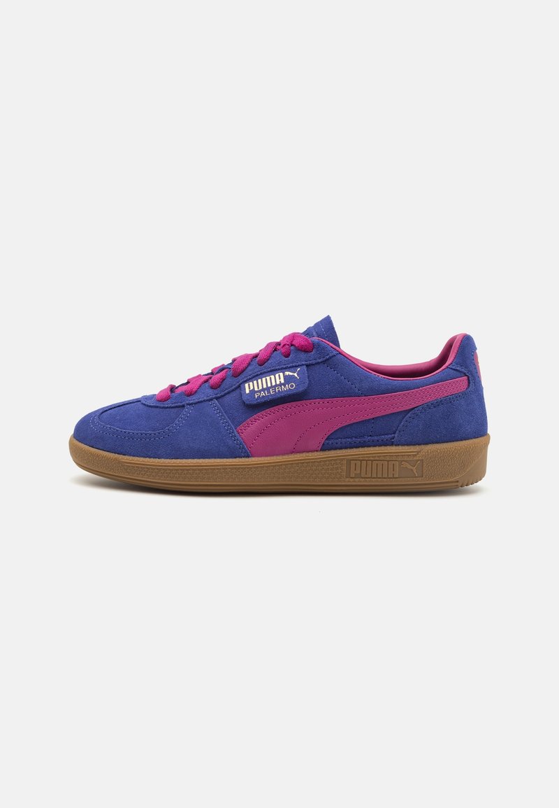 Baskets basses Puma en daim bleu avec des bandes roses, des lacets roses et une semelle en gomme marron, vues de côté.