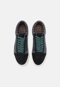 Sneakers with a black suede toe cap and grey textile upper. Features teal laces and a checkered brown interior lining.