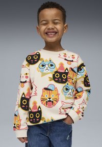 Felpa a maniche lunghe color crema con facce di gatti colorate in vari design. Presenta polsini a coste e una vestibilità comoda.