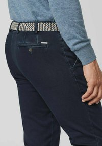 Dunkelblaue Jeanshose aus Denim mit einem gewebten Gürtel in Beige und Schwarz. Verfügt über eine Gesäßtasche mit Knopf und einem dezenten Logo.