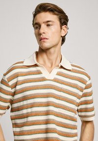 V-neck knitted polo shirt featuring horizontal stripes in orange, cream, and green. Short sleeves with a contrasting white collar.