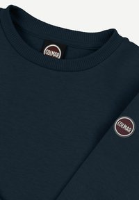 Námornícky modré mikina s rebrovaným okrúhlym výstrihom, jemnou textúrou a kruhovou nášivkou s logom 'Colmar' na rukáve.