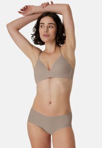 Sømløs beige bh med V-hals og justerbare stropper, kombineret med matchende hipstertrusser, begge lavet af blødt, elastisk materiale.