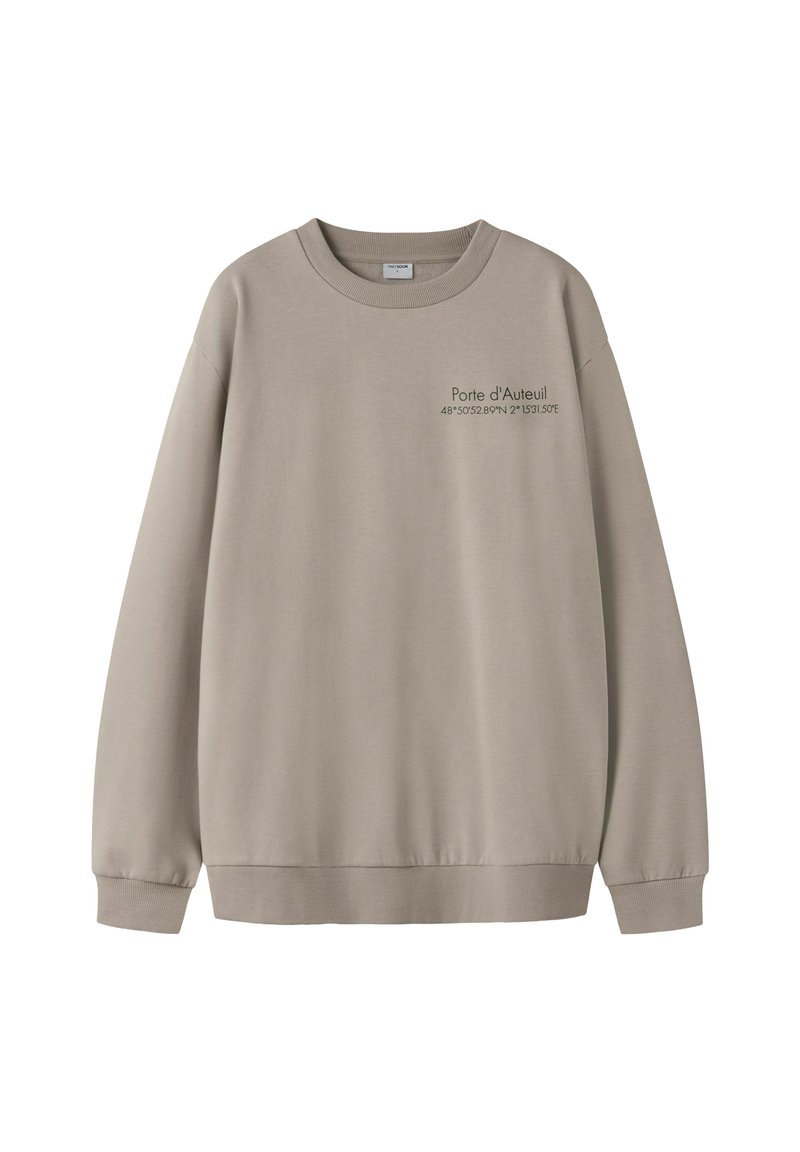 Beige sweatshirt med lange ærmer og rund halsudskæring. Tekst på fronten lyder "Porte d'Auteuil" med koordinater nedenunder. Blødt stof og ribstrikkede manchetter.