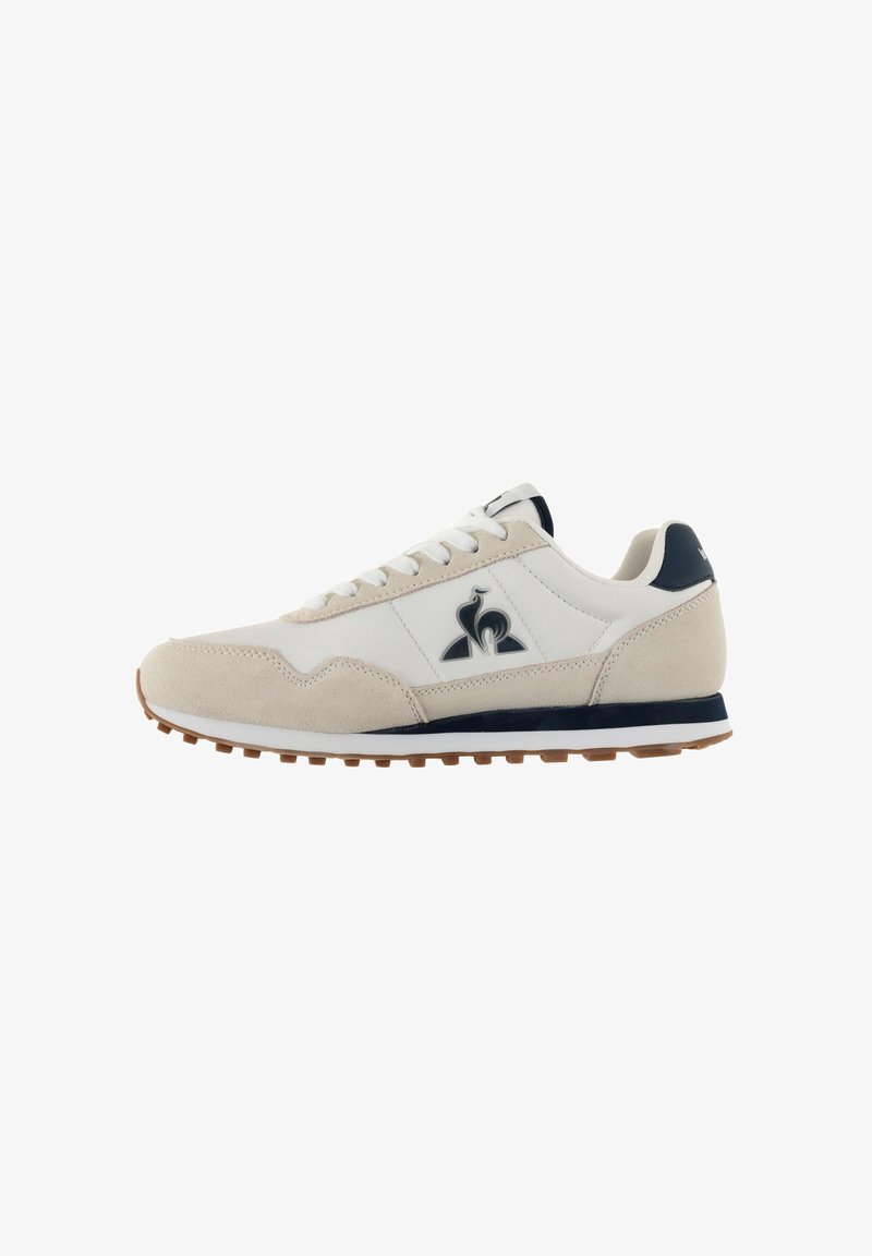 Beige and white sneaker featuring a suede and synthetic upper, lace-up closure, navy accents, and a cushioned rubber sole.
