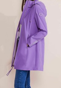 Lila vattentät jacka med huva, hel dragkedja och sidofickor; har reflektionsdetaljer på ärmarna; släta textur.