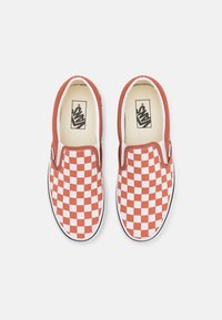 Rot-weiße karierte Slipper aus Canvas mit weißem Futter und einer schwarzen Gummisohle. Minimalistisches Design, keine Schnürsenkel.