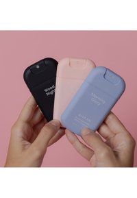 Tres botellas de gel desinfectante: negra "Wood Nights", rosa pastel "Bright Rose" y azul claro "Morning Glory". Formas lisas y redondeadas con etiquetas.