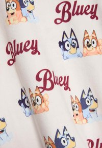 Tela de forro con coloridos perros de dibujos animados con diversas expresiones y la palabra "Bluey" en burdeos, sobre un fondo claro.