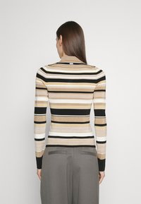 Langarm, tailliertes Hemd aus geripptem Stoff mit horizontalen Streifen in Schwarz, Beige und Creme, einem Stehkragen und einem dezenten Logodetail.