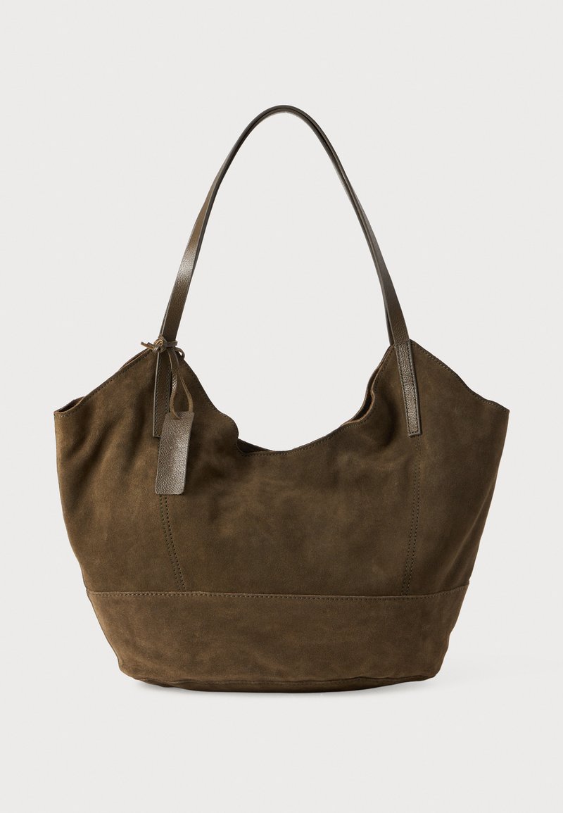 Bruine suède tote bag met een zachte textuur, een gebogen bovenkant en lange leren handvatten. Bevat stikseldetails en een klein leren label.