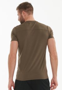 Kortærmet t-shirt i olivengrøn, tætsiddende design, glat tekstur, med en subtil linje over skuldrene. Ingen synlige logoer eller mønstre.