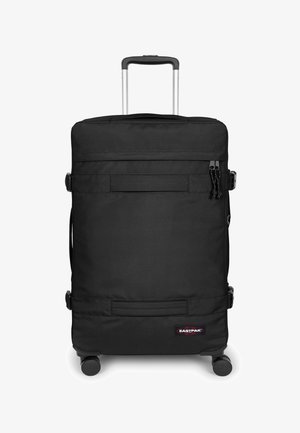 Zwarte koffer met wielen, gemaakt van duurzame stof. Voorzien van een uitschuifbaar handvat en meerdere compartimenten, met een opvallend logo in de rechteronderhoek.