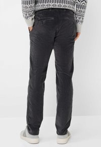 Pantaloni in corduroy grigio scuro con righe verticali, dotati di due tasche posteriori, una vita regolabile e un design a gamba dritta.