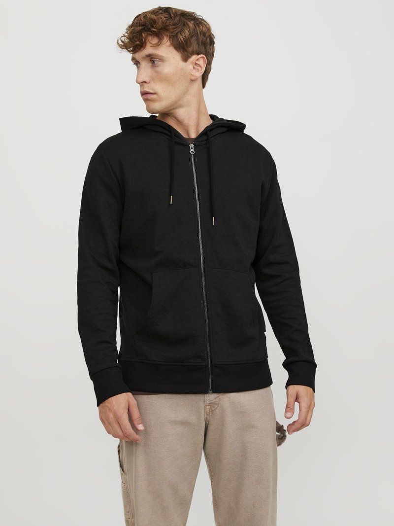 Zwarte zip-up hoodie met een trekkoord capuchon, zakken aan de voorkant en ribgebreide mouwen. Gemaakt van zacht materiaal en heeft een strakke, minimalistische uitstraling.
