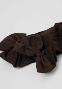 Bruna knähöga strumpor med två stora, texturerade satinrosetter upptill. Rosetterna är mörkbruna och matchar strumpfärgen. Mjukt, elastiskt material.