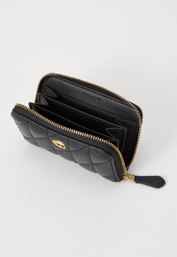 Black quilted leather wallet with gold zipper detail, interior card slots, and a logo. Features a zip-around design with a smooth texture.
