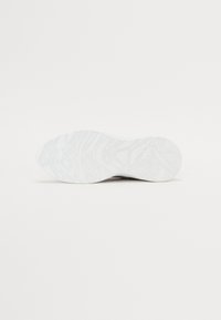Sola de ténis em branco com padrões texturizados, apresentando uma superfície suave e ligeiras curvas para aderência e flexibilidade.