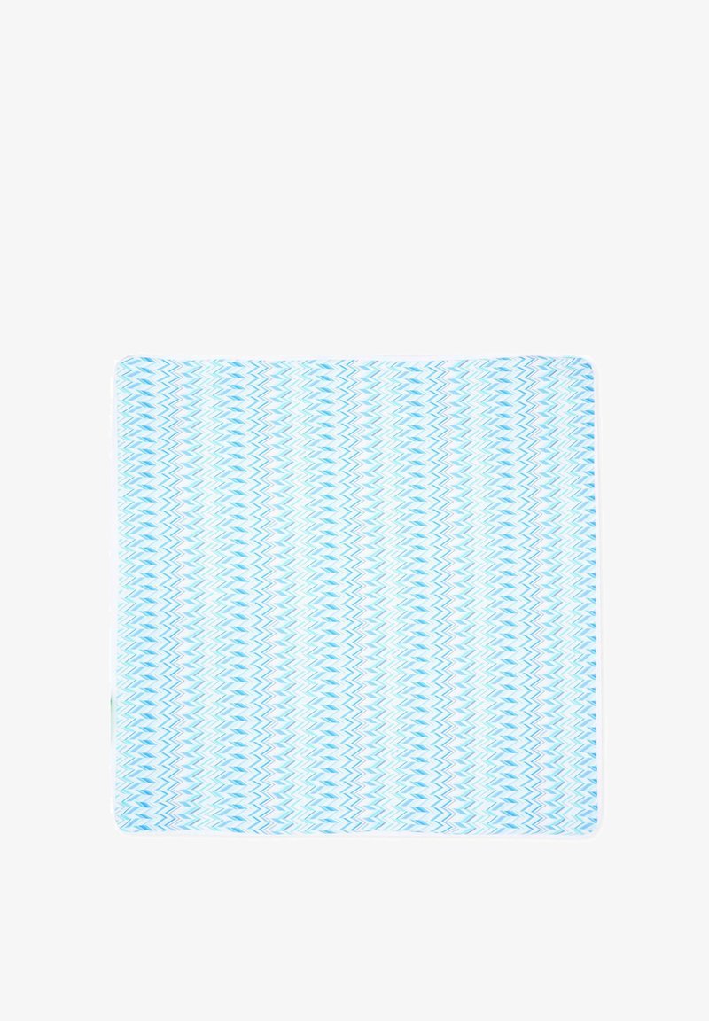 Prostokątny niebiesko-biały dywanik łazienkowy z zygzakowatymi paskami w różnych odcieniach niebieskiego na białym tle.