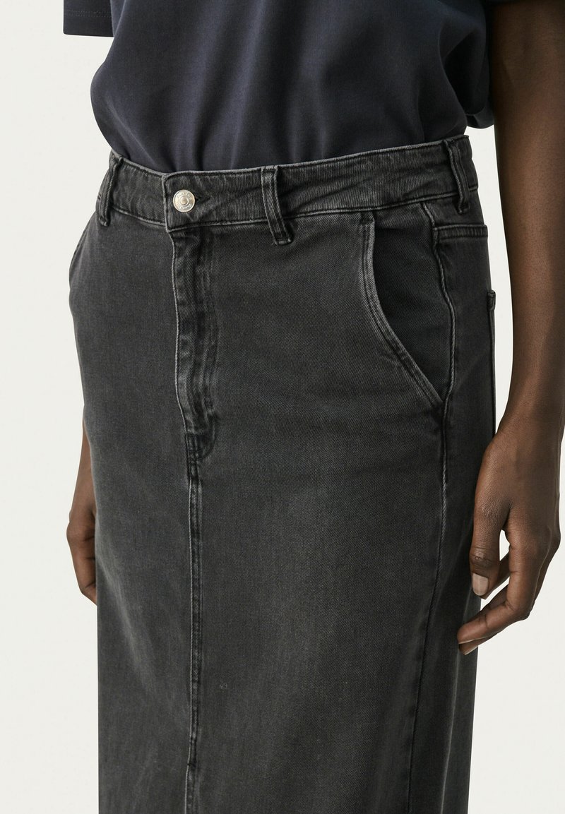Czarna spódnica dżinsowa z wysokim stanem, z przodem zapinanym na guziki, bocznymi kieszeniami i prostym krojem. Gładka tekstura z subtelnymi detalami w odcieniach.