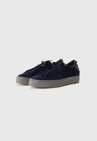 Baskets en daim bleu marine avec une semelle plateforme grise texturée, arborant un design à lacets et des accents cloutés sur le talon.