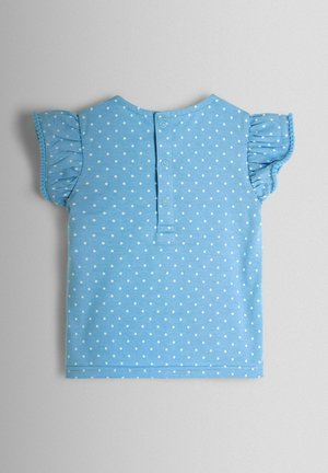 Jasnoniebieska bluzka z krótkim rękawem w białe kropki, z falbankami na rękawach i zapięciem na guziki z tyłu. Wykonana z miękkiej bawełny.