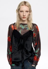 Czarna warstwowa bluzka z przezroczystym kwiatowym rękawem; koronkowa lamówka na dekolcie i sznurek w talii. Tkanina o fakturze z różną przezroczystością.