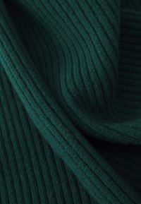 Mørkegrøn ribbet stof med et struktureret strikkemønster, synlige fibre og et blødt, vævet udseende.