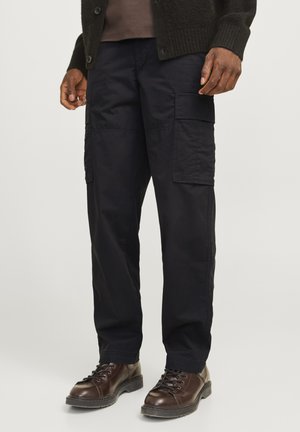 Navy cargo pants made from durable fabric, featuring multiple side pockets and a relaxed fit. Paired with brown lace-up boots.