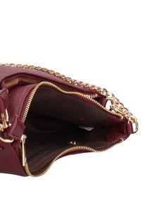 Borsa a mano in pelle bordeaux con tracolla a catena dorata, apertura con cerniera e morbida fodera interna. Presenta due tasche interne con cerniera per l'organizzazione.