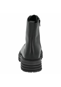 Botín negro de cuero hasta el tobillo con un zipper vertical, puntera redondeada, suela de goma gruesa con estrías y marca sutil en el lateral.
