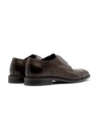 Zapatos de vestir de cuero marrón con un acabado suave, con puntera redondeada, diseño con cordones y una suela de goma negra resistente.