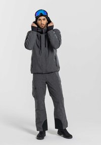 Gray insulated ski jacket with a high collar and dual zip pockets, paired with matching gray pants featuring reinforced cuffs and cargo pockets.