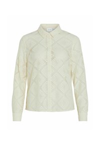 Blouse de couleur crème avec un motif en losanges en dentelle, présentant un col et une fermeture boutonnée à l'avant. Les manches longues se resserrent aux poignets.