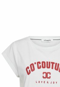 T-shirt en coton blanc à manches courtes, col rond, avec le texte imprimé en rouge "GO'COUTURE" et "LOVE & JOY" en dessous dans une police en gras.