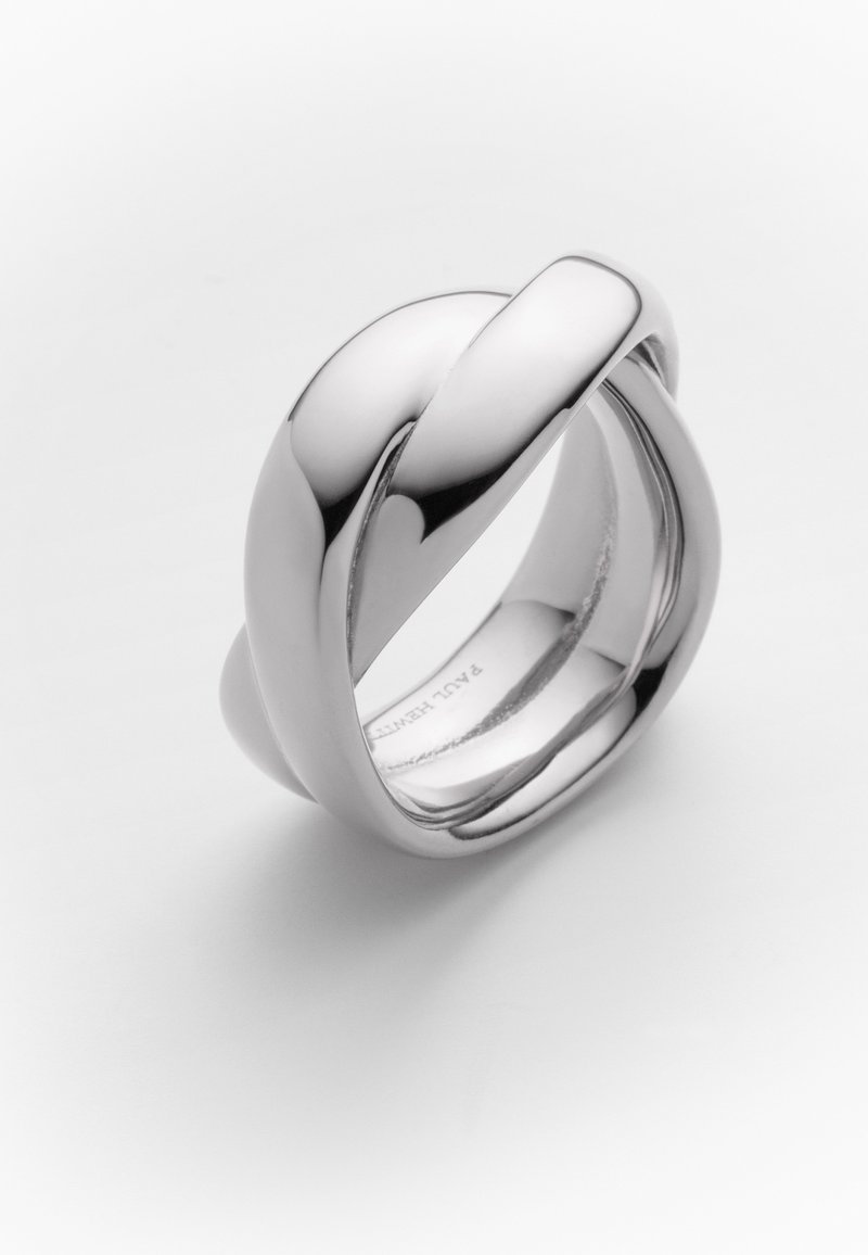 Bague en argent avec un design tordu, présentant une surface lisse et polie ainsi que des bords arrondis, créant une boucle continue sans points durs.