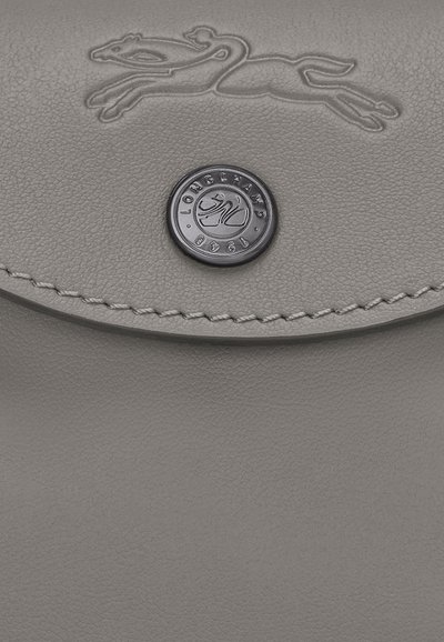 Gray leather wallet with a textured surface, featuring an embossed logo and a black snap closure. Edge stitching adds detail.